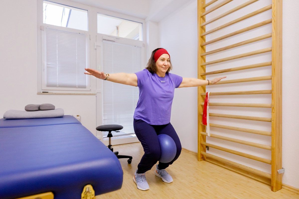 Paciente realizando un ejercicio postural junto a las espalderas